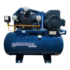 A blue industrial air compressor with a 3 HP motor and large cylindrical tank reads General Air Products. It has two gauges, a cooling fan, and piping for integration with fire suppression systems.